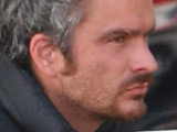 Balthazar Getty holding a wad of dollar bills and eating on a bench in Cross Creek, Malibu with a young companion, Los Angeles