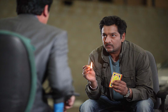Masood taunts Yusef with the fake can of petrol he puts in front of him.