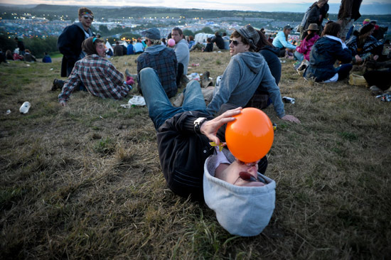 A reveller inhales a nitrous filled balloon