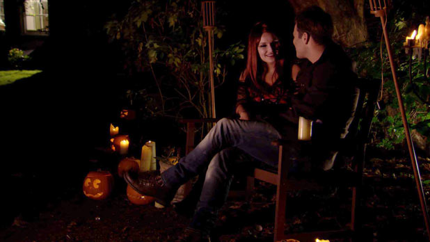 Mark and Sam sit on a bench outside at Halloween party