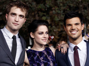 Robert Pattinson, left, Kristen Stewart, center, and Taylor Lautner arrive at the world premiere of "The Twilight Saga: Breaking Dawn - Part 1"