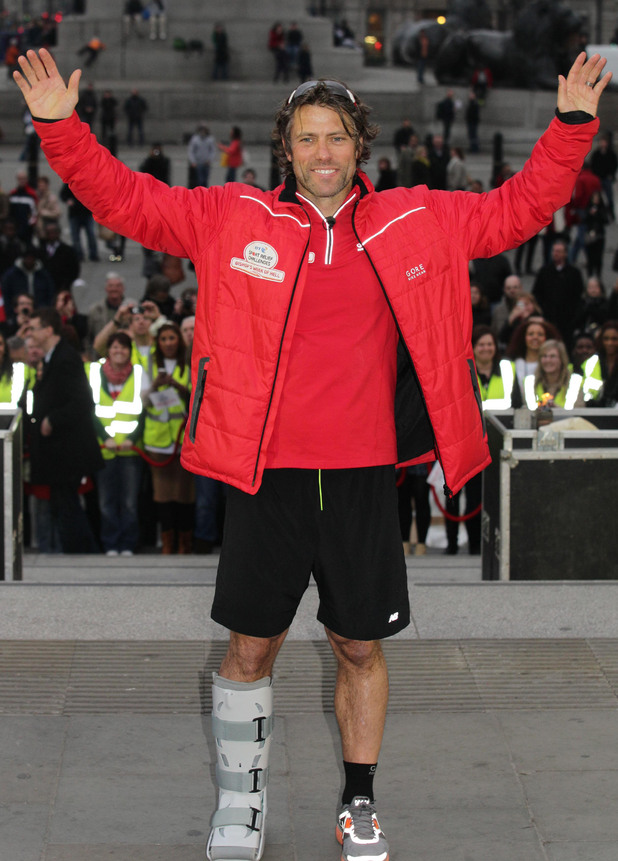 Comedian John Bishop celebrates after completing his 290 mile triathlon from Paris to Trafalgar Square in central London