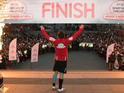 Comedian John Bishop celebrates after completing his 290 mile triathlon from Paris to Trafalgar Square in central London