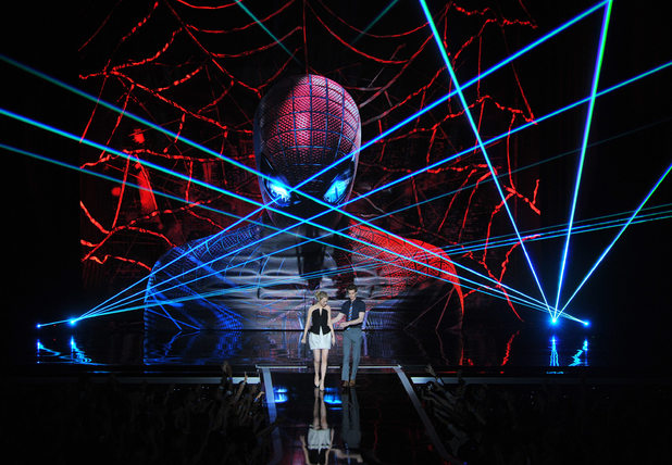Emma Stone and Andrew Garfield appear against a dramatic <em>Amazing Spider-Man</em>-themed backdrop