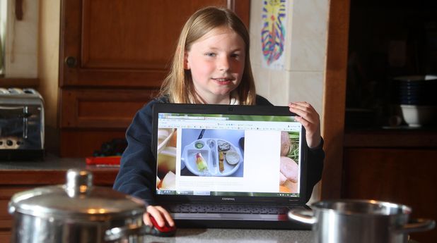 9-year-old Martha Payne with a laptop showing her blog 'NeverSeconds'