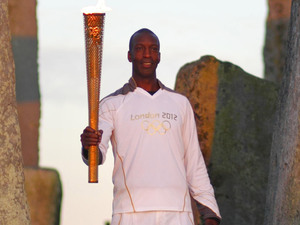Michael Johnson holds the Olympic Torch at Stonehenge