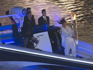 David Beckham arrives by boat with the Olympic Torch.