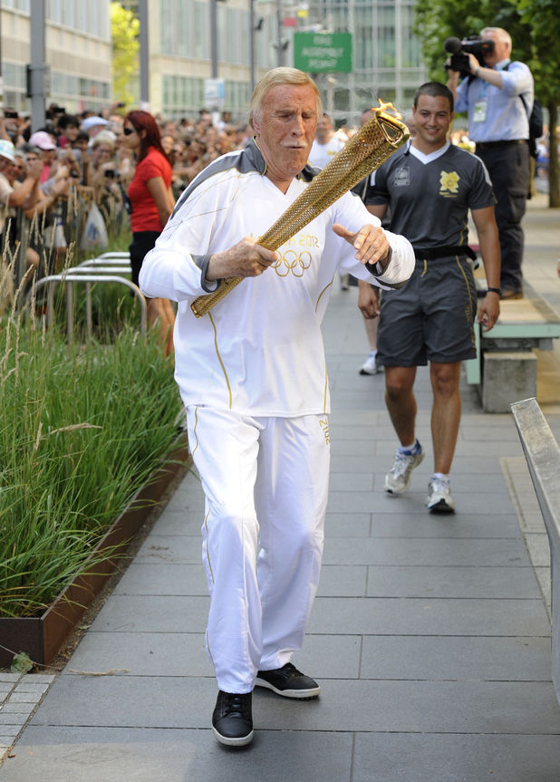 Bruce Forsyth carries the Olympic Flame on the Torch Relay leg through Kensington and Chelsea