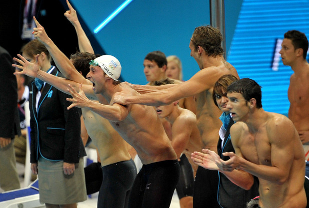 The French team celebrate Gold ahead of Michael Phelps (right) and the USA team in Silver in the 4 x 100m Freestyle Relay, Clement Lefert, Amaury Leveaux, Fabien Gilot, London 2012