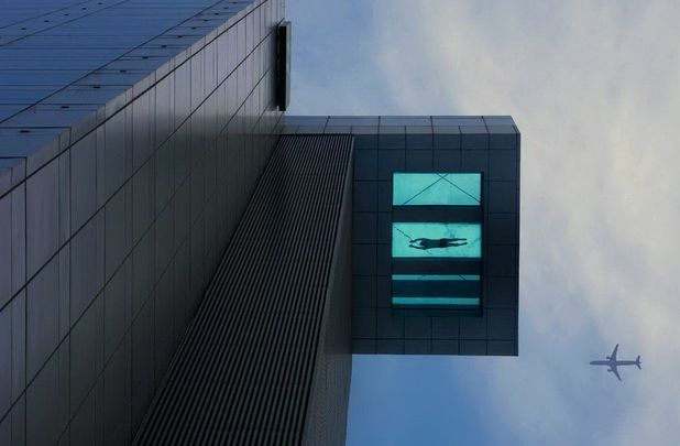 24th floor swimming pool with transparent bottom extends over side of Holiday Inn Hotel, Shanghai, China