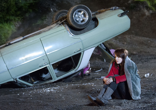 Summer sits near the car wreck.