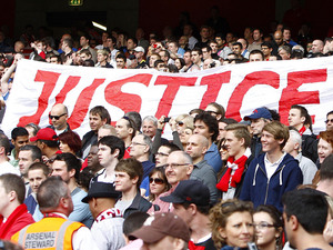 Liverpool fans hold up a banner relating to the Hillsborough disaster