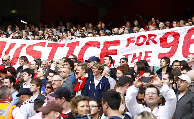 Liverpool fans hold up a banner relating to the Hillsborough disaster