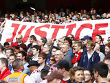 Liverpool fans hold up a banner relating to the Hillsborough disaster