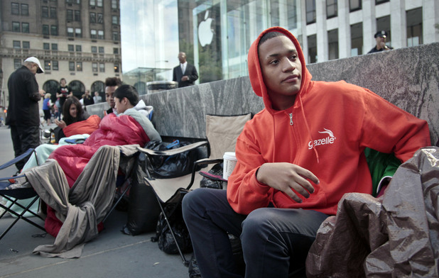 Joseph Cruz, 19, far right, from Staten Island, N.Y., waits on line outside Apple's Fifth Avenue store on Thursday, Sept. 20, 2012, in New York. Cruz, who started camping last Friday to be one of the first to get the new iPhone 5, said "it's unique, I just love the iphone."