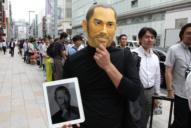A customer wearing a mask of Steve Jobs