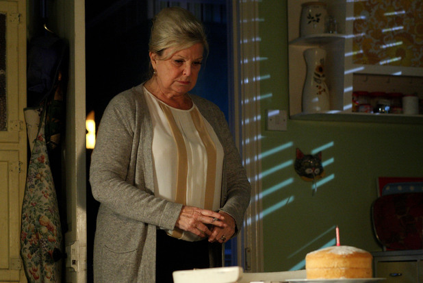 Cora looks at a birthday cake she made for her daughter Ava.