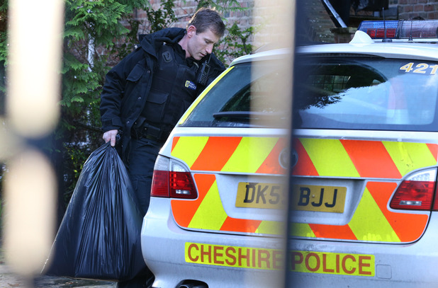 A police officer carrying a plastic bags from the home of Stuart Hall in Wilmslow, Cheshire following the arrest of the veteran BBC commentator over allegation of rape and indecent assault.