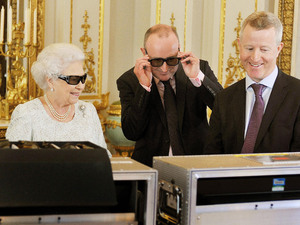 Queen Elizabeth II with producer John McAndrew and director John Bennett (right), in the White Drawing Room of Buckingham Palace in central London, as they watch the recording of her Christmas message to the Commonwealth which is to be broadcast in 3D for the first time.