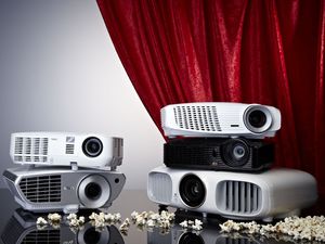 A Selection Of Projectors Photographed In Front Of A Cinema-style Curtain And Popcorn