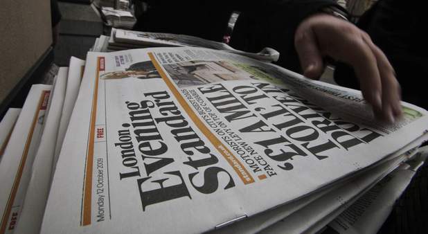 A man collects a free copy of the Evening Standard daily newspaper