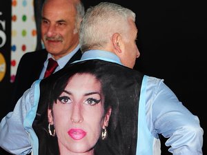 Mitch Winehouse arrives wearing a waistcoat bearing a picture of his daughter Amy at the 2013 Brit Awards