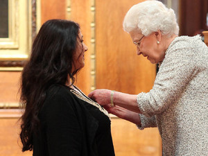 Kate Bush receives her CBE from Queen Elizabeth II during an Investiture ceremony at Windsor Castle
