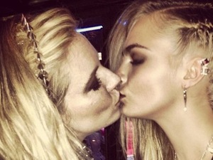 Cara Delevingne kisses Sienna Miller at the Met Ball.