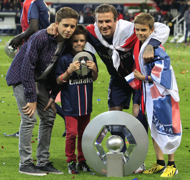 David Beckham and his sons pose with the cup.