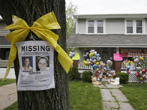 A missing poster rests on a tree outside the home of Amanda Berry