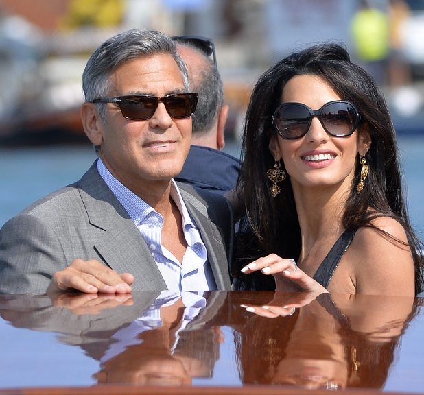 George Clooney (L) and Amal Alamuddin (R), his Lebanon-born British fiancee take a taxiboat upon their arrival in Venice, on September 26, 2014, on the eve of their wedding. AFP PHOTO / ANDREAS SOLARO (Photo credit should read ANDREAS SOLARO/AFP/Getty Images)