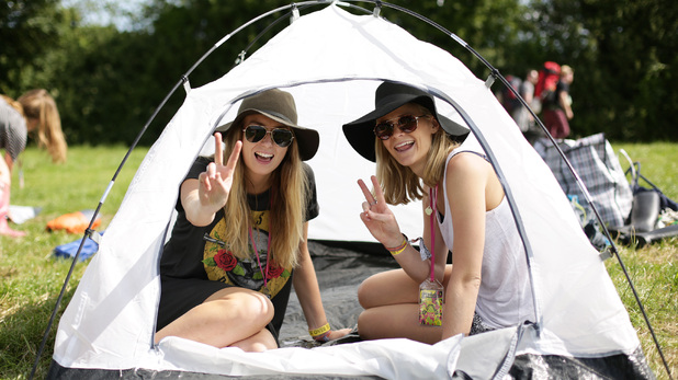 Alix Smith and Jess Buttel from Australia celebrate putting up their tent in a campsite at Glastonbury Festival 2015